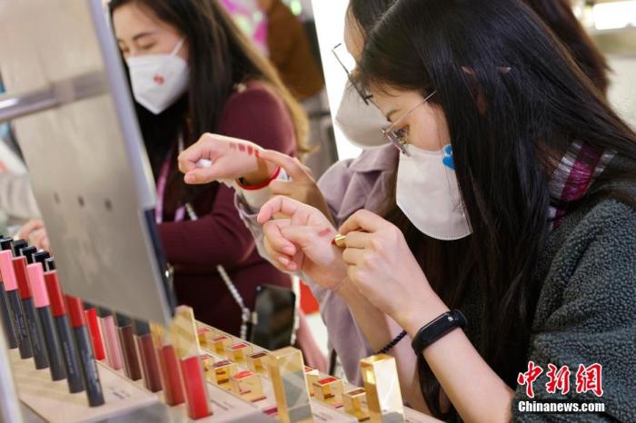 圖為女生正在體驗(yàn)口紅產(chǎn)品。 殷立勤 攝
