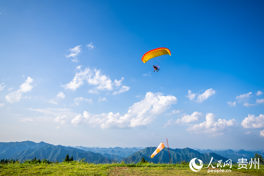 游客在野玉海飛行營(yíng)地乘動(dòng)力滑翔傘體驗(yàn)云端觀景。人民網(wǎng)記者 涂敏攝