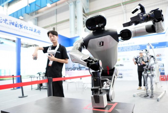 9月5日，在沈陽的2025全球工業(yè)互聯(lián)網(wǎng)大會的展覽區(qū)現(xiàn)場，中國科學(xué)院沈陽自動化研究所的機器人工程師在調(diào)試具身智能操作系統(tǒng)。新華社記者 李鋼 攝